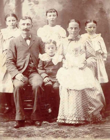 Samuel Jefferson Adams & his wife Cora Edith (Painter) Adams with their children.

Back row:  Bonnie Pearl (Adams) Wells, Bessie (Adams) Kidd, Beaulah Adams.
 
Samuel Jefferson Adams & his wife Cora Edith (Painter) Adams are holding two of their 2 sons.

Photo courtesy of Kim Fowles.