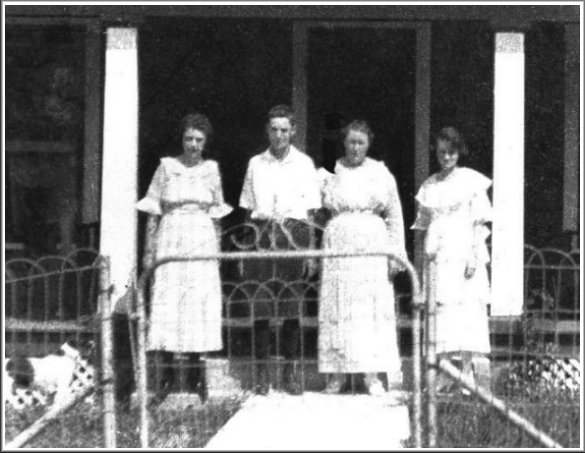 Annie Barnett with her two daughters and her nephew: from left: Geneva Barnett, Glen Moreton, Annie (Allender) Barnett and Nellie May Barnett in front of the Barnett home in Wilmore, Comanche County, Kansas. This photo was copied from one in the collection of Nellie May (Barnett) Ferrin.