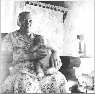 Anna (Allender) Barnett, at home, Wilmore, Comanche County, Ks, with her great-grandson, Darrell Gene Ferrin, who was born July 3, 1950.