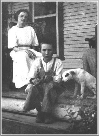 Nellie May Barnett with her first cousin, Glenn Moreton, son of Lilly (Allender) Moreton, at the Anna (Allender) Barnett home in Wilmore, Comanche County, Kansas. After his mother died, Glenn Moreton was reared by his Aunt Annie Barnett. Copied from a photo in the collection of Nellie May (Barnett) Ferrin of Wilmore, Kansas.