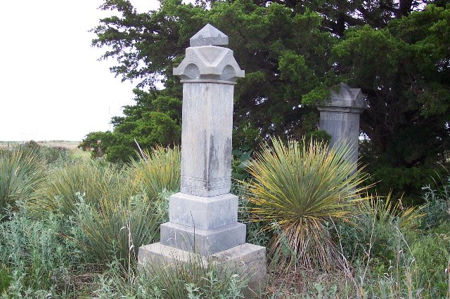 Two gravestones in Aetna Cemetery, Barber County, Kansas.

The stone at center is for J.B. Johnson; at right is the stone for Louise McComb.

Photo by Phyllis Scherich