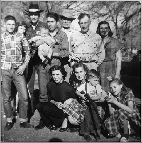 From left, back row: Donald Eugene Norton, Betty (Lacey) Norton, William Robert 'Bill' Norton, Jerry D. Ferrin being held by his grand uncle, Carl Eugene Grauberger, Robert Emmet Norton, Carl Grauberger, Gladys Leota (Grauberger) Norton. Front row: Laverne _______(?) Grauberger, Alice Lorene (Norton) Ferrin, Darrell G. Ferrin, Wanda Leota Norton. Photo by Wendel Ferrin, late 1952, Protection, Comanche County, Kansas.