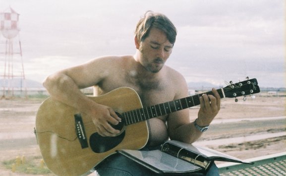 Doug Alexander, playing an F major chord on his Fender guitar, National Parachute Test Range, El Centro, California.

Photo by Pat 'Smitty' Smith.