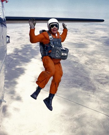 A Parachute Rigger / Test Parachutist exits a plane at the National Parachute Test Range, El Centro, California, circa 1976.

Photo by PHAN/PH3 Charles 'Chuck' Lohman.