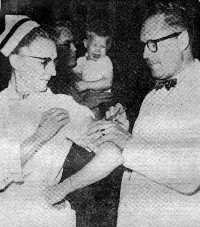 TURN ABOUT - Even the nurses were on the receiving end of the needle during moss inoculation ceremonies Monday in Protection, Kansas. Here, Dr. Lyle G. Glenn gives Mrs. Edith Martin her final shot in the three-shot Salk series. The nurse, trying to be as brave as possible, failed to convince the little boy in the background that the whole thing was painless.   (Photo by Jerry Clark, Protection Beacon chief photographer).

CLICK HERE TO READ THE ENTIRE ARTICLE.