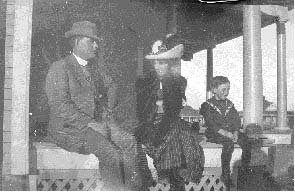 Harvey and Grace Schrock with their son, John Edward, on the porch of their home in Wilmore, Comanche County, Kansas.