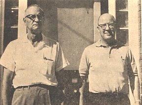 Operating the Wilmore Bank during the absence of F. H. Moberly, who is in Europe on a tour, are Myrl Dellinger, cashier, at the left, and Walter Smith, assistant cashier.  Mrs. Moberly, who is assistant cashier and director, has not been working at the bank since the busy harvest season.