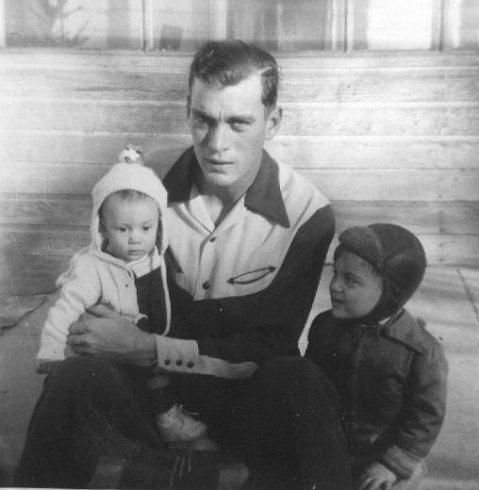 Wendel Ferrin holds his 2nd son, Jerry, while his oldest son, Darrell, sits beside him. Taken at the Ferrin farm, Comanche County, Kansas, December 1952.