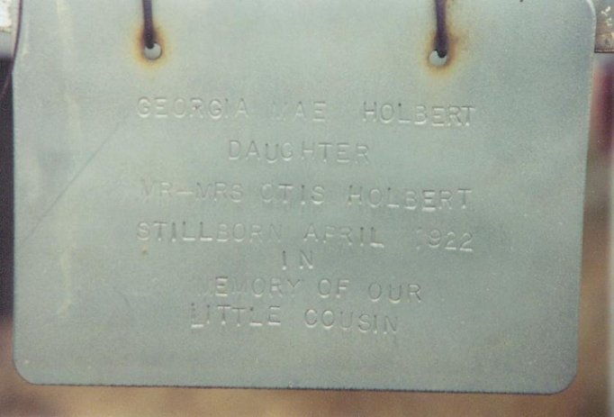 Name plate on the enclosure surrounding the  grave of Georgia Mae Holbert, Still born, Comanche County, Kansas. Photo courtesy of Bobbi Huck.