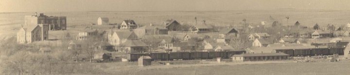 Aerial view of Wilmore, Comanche County, Ks.  The large brick building at left is now the Federated Church; behind it is the original Wilmore High School.  Photo copyright John Edward Schrock 1950