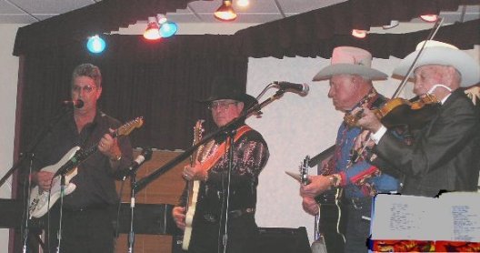  The Dodge City Wild Bunch at the November 1, 2003, Wilmore Opry:  Jerry Miller on guitar  (from Sublett, Ks.); Ike Ritter on Bass (from Dodge City, Ks.); Joe Coyne on guitar (from Lakin, Ks.); Fred Voelker,  92 years old, on fiddle (from Fort Dodge, Kansas).